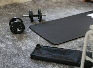 a pair of dumbbells and a black mat on the floor