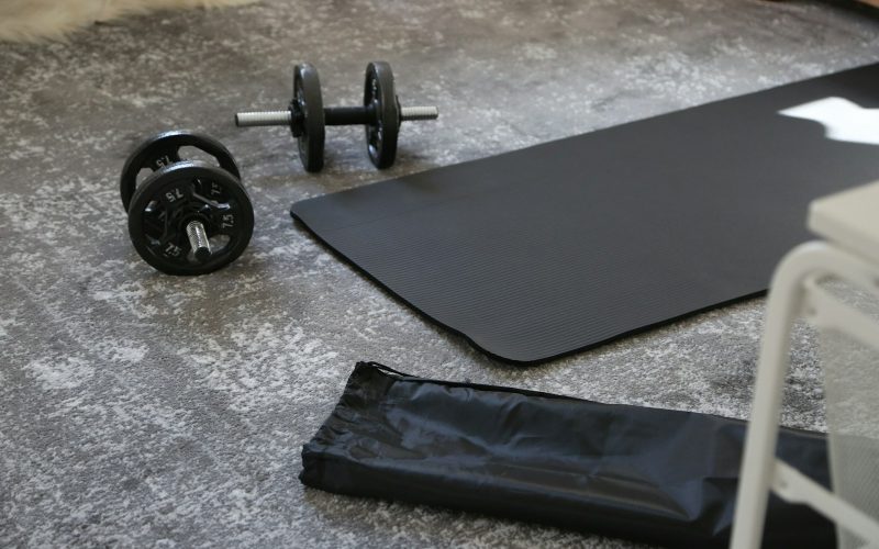 a pair of dumbbells and a black mat on the floor